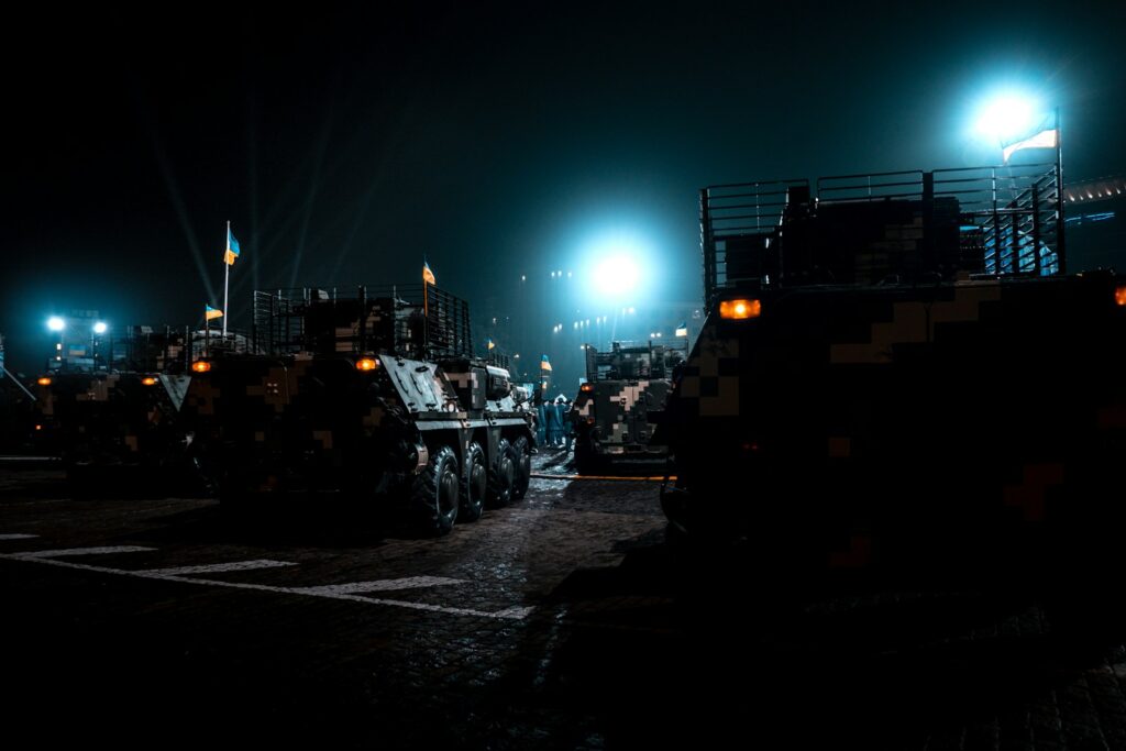 military vehicles parked in a parking lot at night